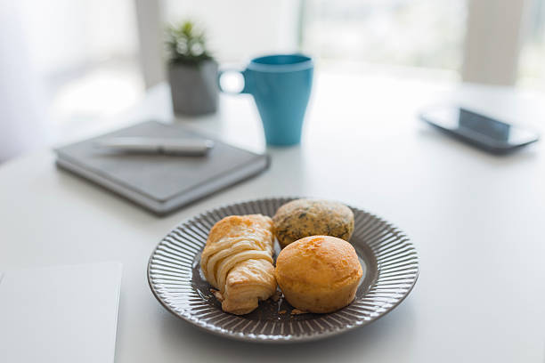 Freshly baked pastries and muffins are ready to be enjoyed during a productive office breakfast