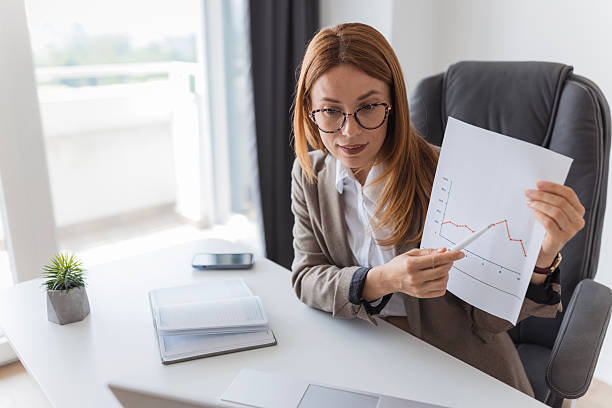 istock Businesswoman showing declining graph during video conference 2233690755