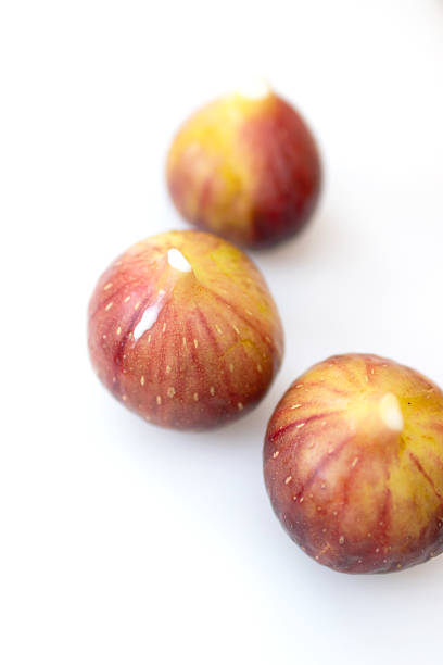 Fresh, ripe figs arranged artistically on a light background, showcasing their natural beauty and vibrant colors.