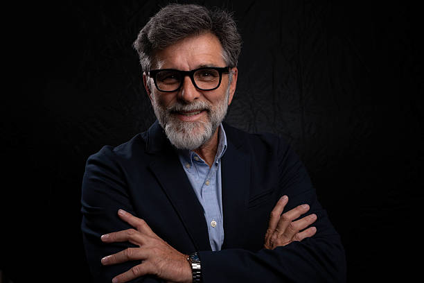 istock Confident mature businessman with beard posing in dark background 2233698188