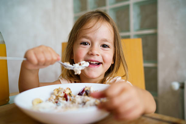 istock Cute little girl is having breakfast at home. 2233702896