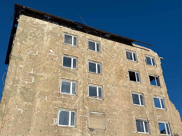 istock Abandoned building with broken windows against clear blue sky 2233710432