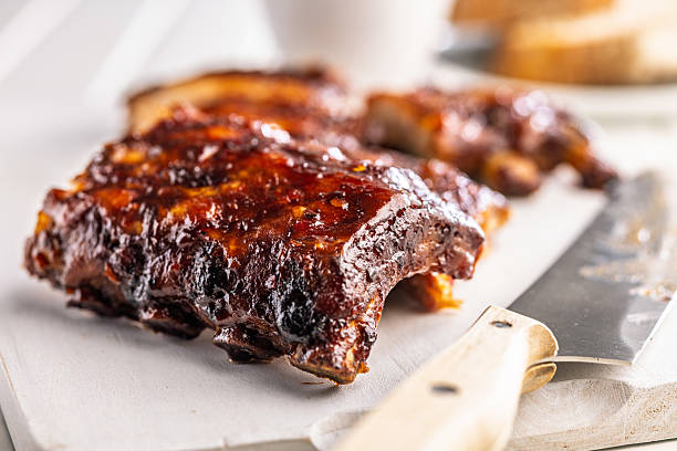 istock Pork BBQ glazed ribs on white cutting board. 2233714388