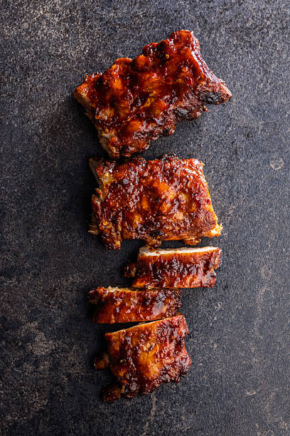 istock Pork BBQ glazed ribs on black table. Top view. 2233714446