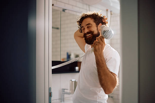 istock Happy man drying his hair in the bathroom. 2233714582