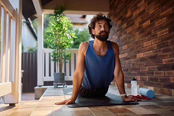 istock Male athlete in cobra pose stretching while working out on the porch. 2233714719