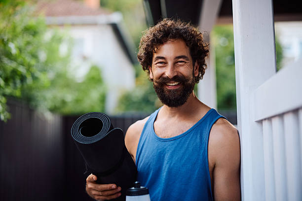 istock Happy athlete with Yoga mat in the backyard looking at camera. 2233714921