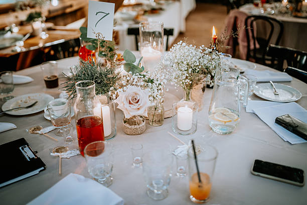 istock Elegant table setting with candles, flowers, drinks, and a table number in a rustic indoor venue, creating a romantic and festive atmosphere. 2233715851