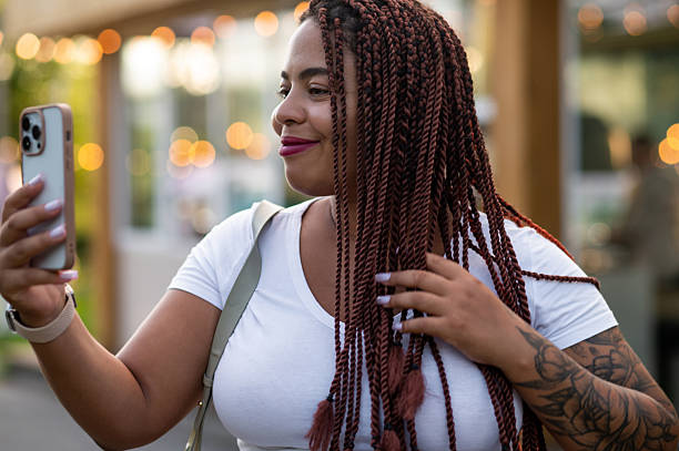 istock Curvy female in stylish jacket smiling while making video call 2233716271
