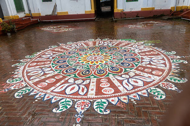 A simple flower arrangement surrounding the statues of Hindu deities Vithal and Rakhmai with a traditional stone grinder. The vibrant flowers enhance the peaceful ambiance with lit diyas sideby, creating a traditional and devotional atmosphere. The arrangement is made for Bangle wearing ceremony for the bride.
