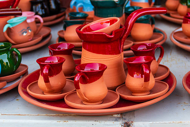 A clay coffee pot and cup set on the market stall.
