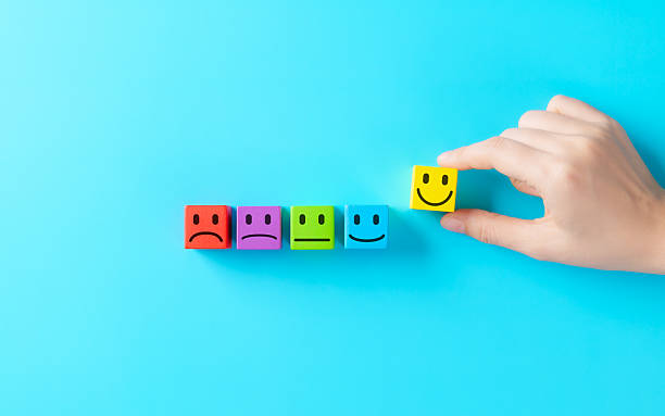 istock Customer Satisfaction Feedback Concept. Hand selecting smiling face block from row of colorful emotion icons representing customer satisfaction, positive feedback, rating scale, emotional experience, 2233722558