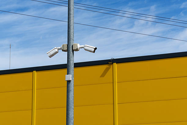 istock two cctv cameras on a pole against a yellow wall and sky, security concept 2233730788