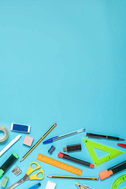 istock School supplies forming a bottom border on blue background with copy space 2233732327