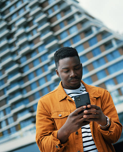 istock Young man using phone in the street 2233734757