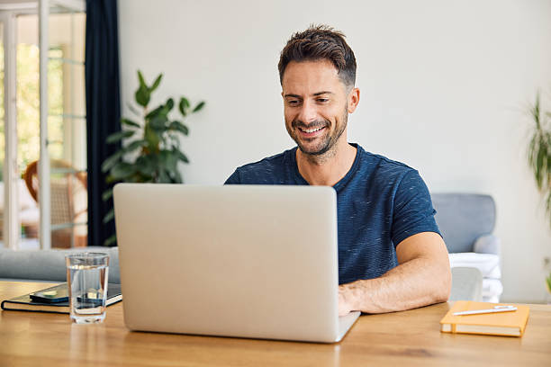 istock Smiling caucasian man working on laptop at home 2233736595