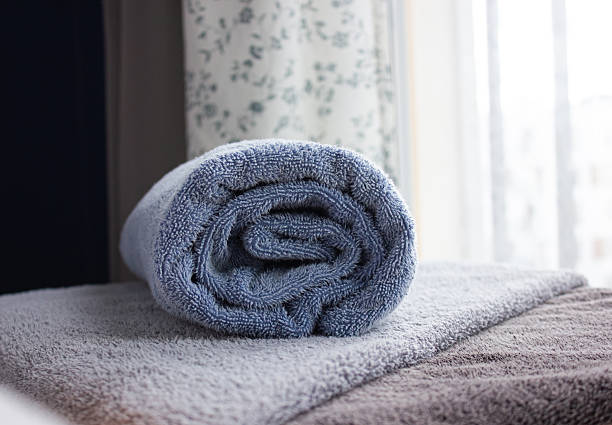 istock Closeup of blue rolled Bath towel. Towel a on table with copy space, blurred background for product display. 2233737773