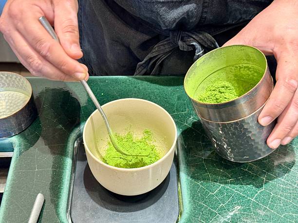 Barista scooping matcha tea powder into a cup at a cafe in New York City
