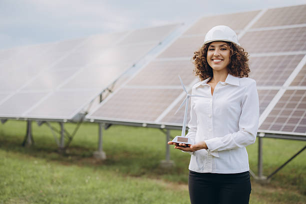 istock Engineer holding wind turbine model promoting renewable energy near solar panels 2233738517
