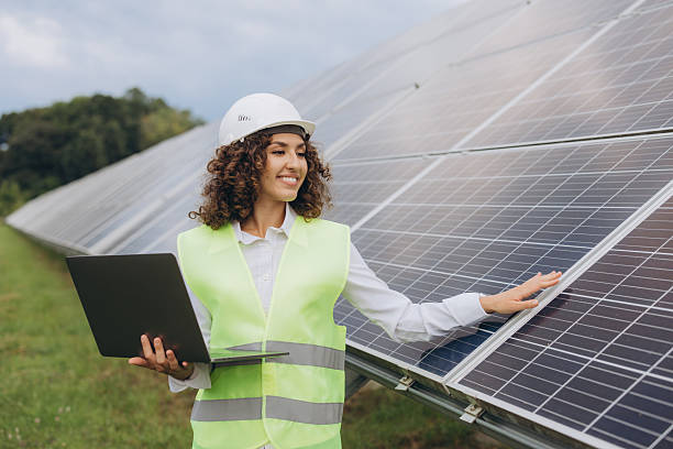 istock Female engineer working with laptop inspecting solar panels in power station 2233739040