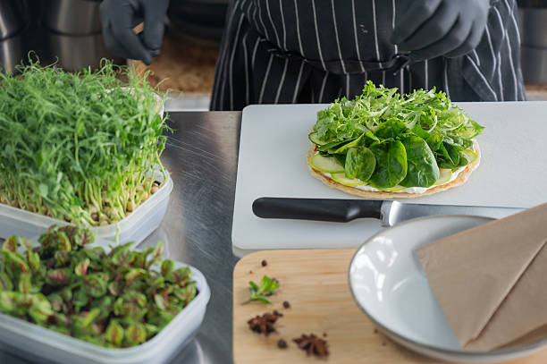 The chef prepares a flatbread with herbs.