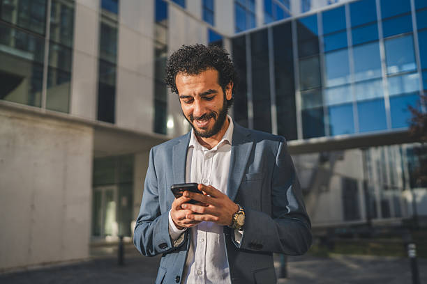 istock Businessman using smart phone in front of office building 2233745293