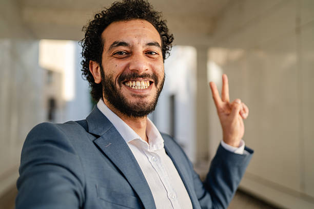 istock Smiling businessman waving and gesturing during video call in hallway 2233745367