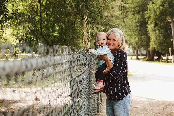 A grandmother and her cute granddaughter looking at each other and laughing in a park