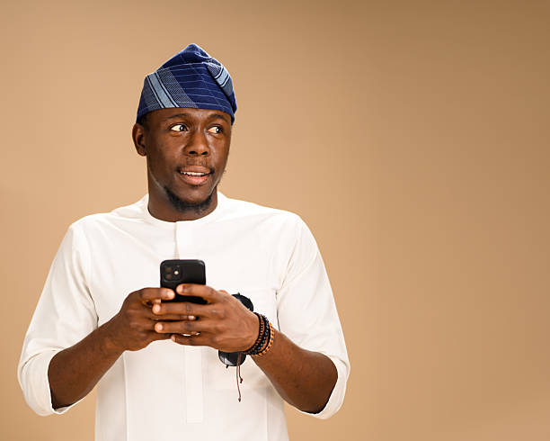 istock Man in Yoruba cap holding smartphone and looking aside 2233748201