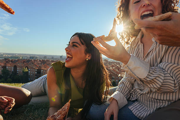 istock Friends eating pizza outdoors in a park, having fun together 2233750466