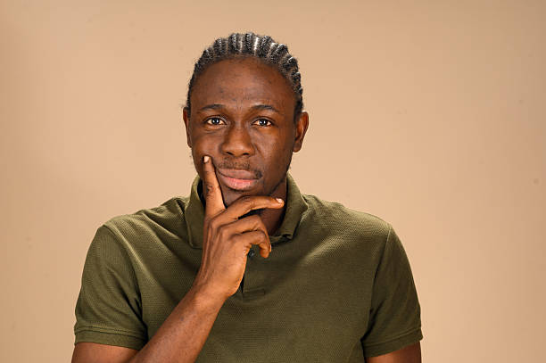 istock African man in green polo shirt touching face with thoughtful expression 2233750741