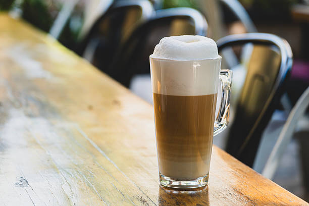 istock Foamy latte in a large glass on wooden table. 2233750963