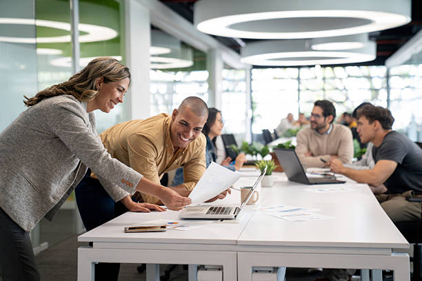 istock Happy business people sharing ideas at the office while looking at a document 2233753802
