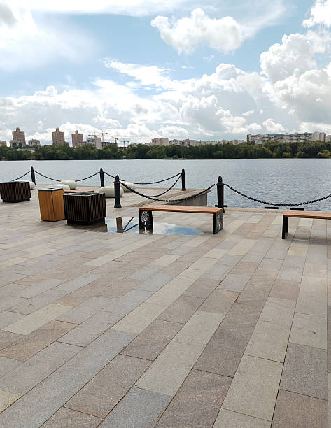 istock Urban waterfront with benches and river view under a cloudy sky 2233759941