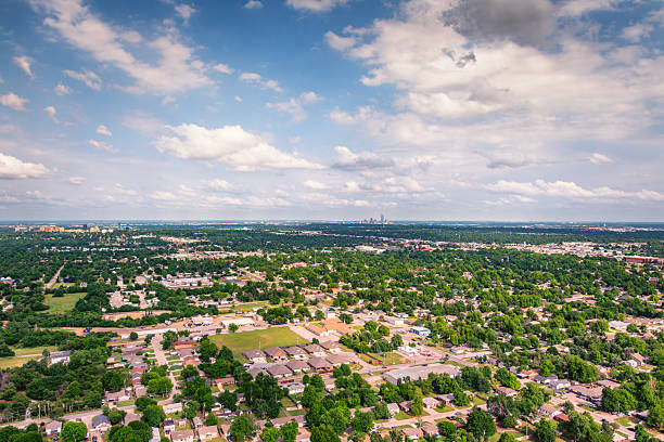 The distant skyline of downtown Oklahoma City shot from above a suburban subdivision via helicopter from an altitude of about 1000 feet.