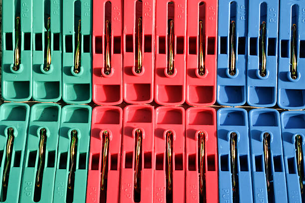 Texture of a stack of red, green and blue plastic clothespins. Close-up Plastic clothespins with a metal spring mechanism in the middle. Wallpapers Backgrounds. Graphic Resources. Macrophotography