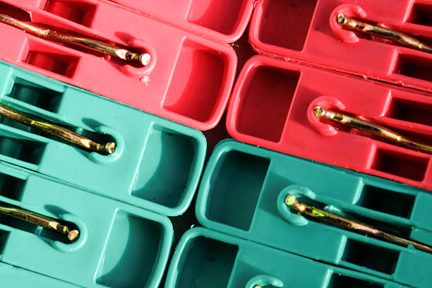 Close-up image of a stack of red and green plastic clothespins. Plastic clothespins with a metal spring mechanism in the middle. Wallpaper Backgrounds. Graphic Resources. Macrophotography