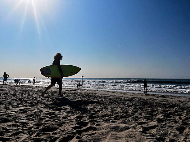 Beachgoers and surfer at Rockaway beach