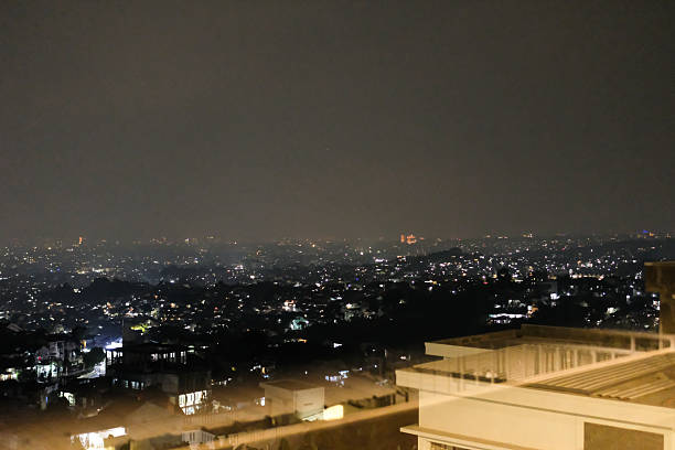 Natural city light at night at Rooftop cafe. Beautiful view of lights on a hillside seen from the rooftop of a cafe. Sparkling lights of houses. Night city view with negative space. Bandung, Indonesia
