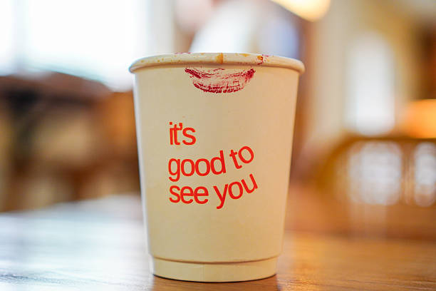istock Coffee Cup with Lipstick Kiss and Friendly Greeting on Cafe Table 2233766966
