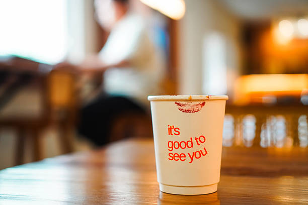 istock Coffee cup with lipstick mark on wooden table in cafe 2233767005