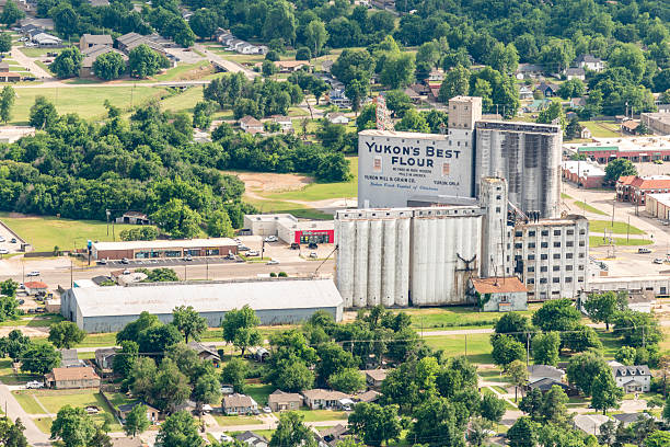 Yukon, United States - May 22, 2025:  Aerial view of the iconic Yukon Flour Mill and grain elevators built in the year 1900, located just off the famed Route 66 near Oklahoma City shot via helicopter from an altitude of about 1000 feet.