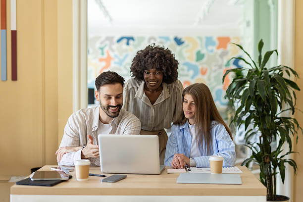 istock Diverse Team Collaborates Over Laptop: Joy and Creativity 2233771140