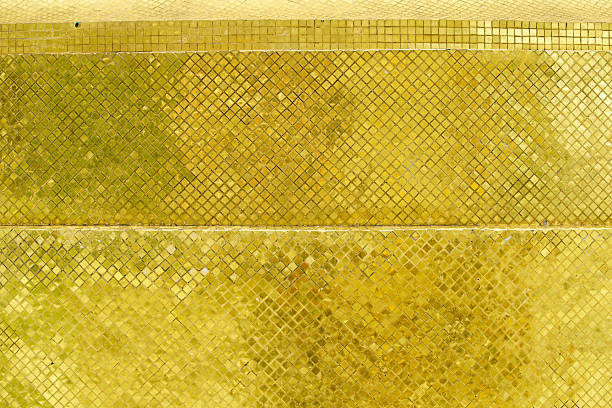 This image showcases a stunning arrangement of shimmering golden mosaic tiles, perfect for enhancing interior design projects with elegance and luxury.
