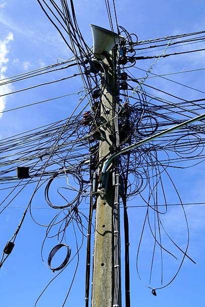 istock Chaotic Wires and Cables on a Utility Pole Against Blue Sky 2233772778