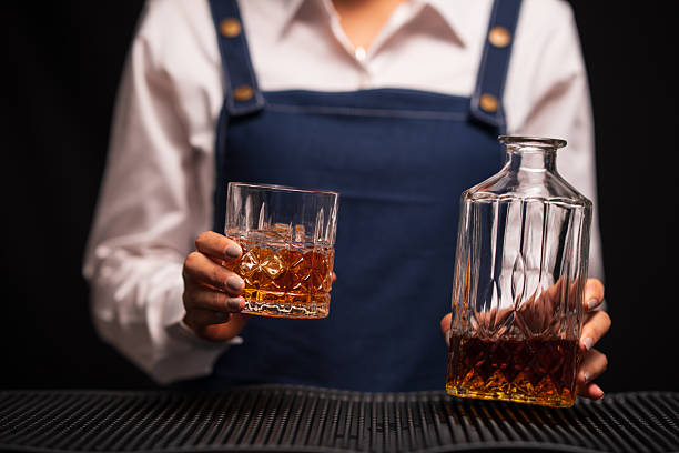 istock Bartender woman pours whiskey into a glass in a restaurant. 2233774947