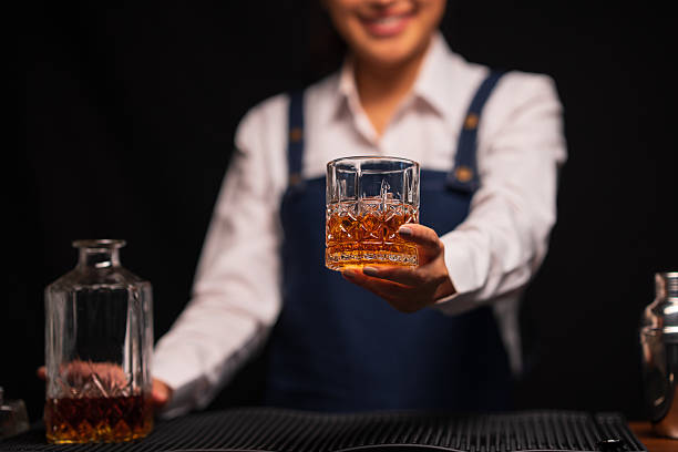 istock Bartender woman pours whiskey into a glass in a restaurant. 2233775010