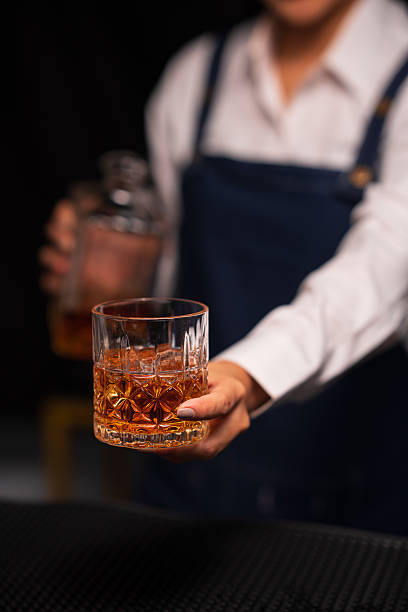 istock Bartender woman pours whiskey into a glass in a restaurant. 2233775018