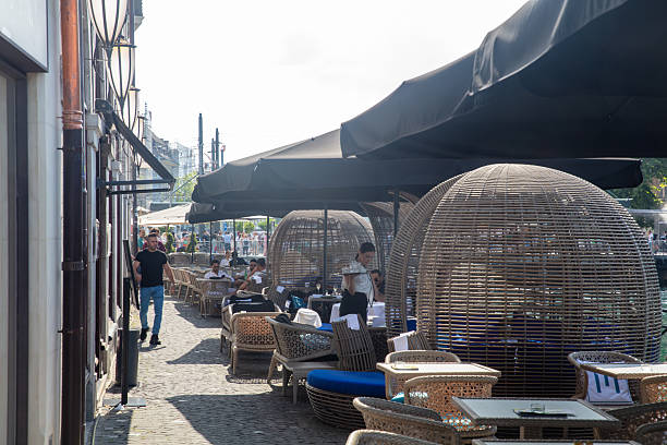 Geneva, Switzerland- July 3, 2025: Street view in Geneva. People are enjoying food on the restaurant outside.