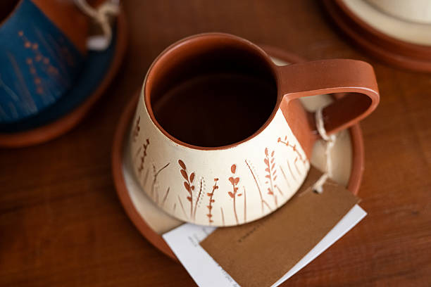 A collection of handcrafted pottery cups arranged beautifully on a dark textured surface, showcasing vibrant colors and exquisite craftsmanship that capture the essence of artistic creativity and self-expression.